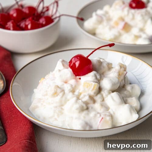 glorified rice in a shallow dish topped with a maraschino cherry.