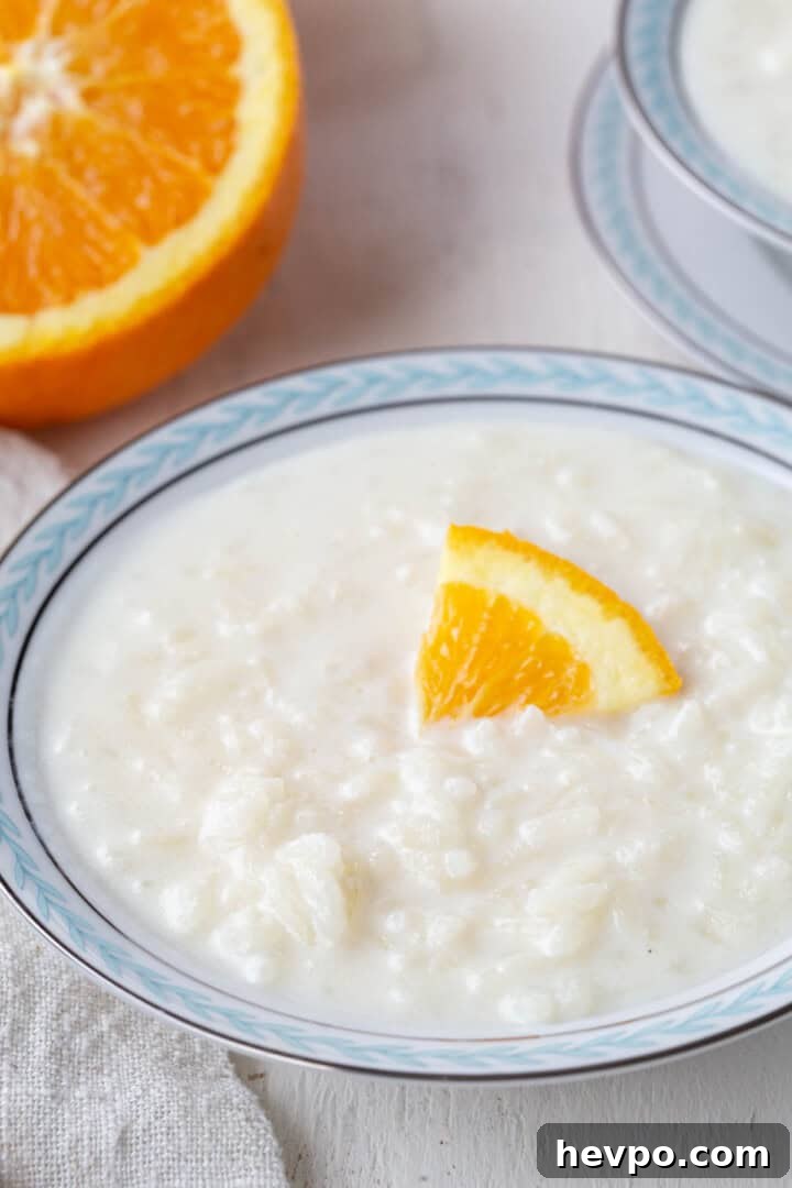Creamy Rice Pudding Made with Cooked Rice 6 bowl of creamy white rice pudding with an orange peel on top.