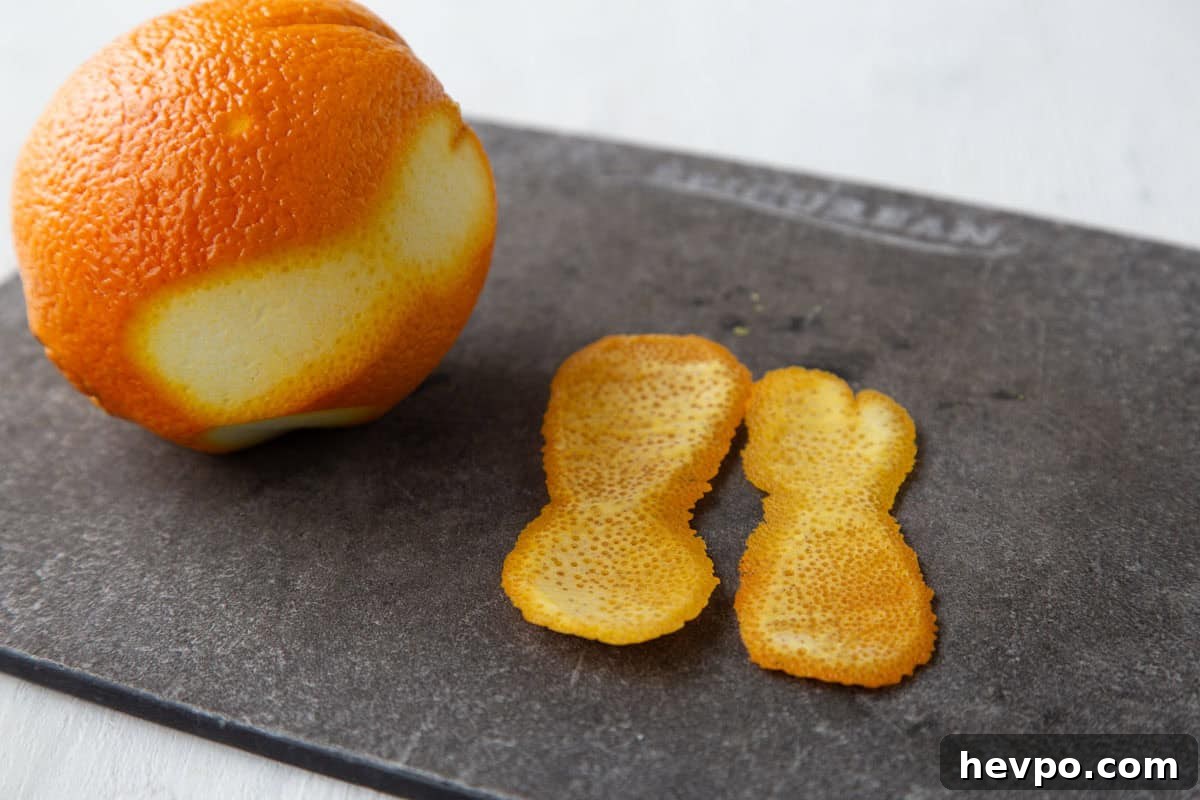 Creamy Rice Pudding Made with Cooked Rice 7 orange peel and a navel orange on a cutting board.
