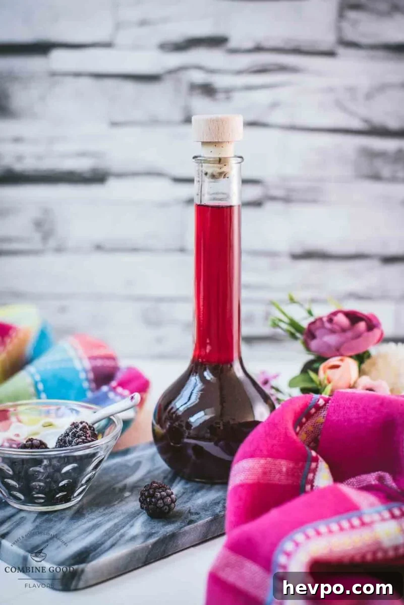 Delicious homemade Chambord, blackberry raspberry liqueur, on gorgeous flask, placed on black slate.