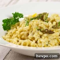 Creamy Lemon Asparagus Risotto Recipe for Spring Meals 3 Creamy asparagus and lemon risotto garnished with parsley and asparagus tips, served in a white bowl.