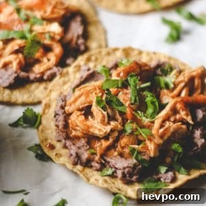 three tostadas with refried black beans and chicken tinga