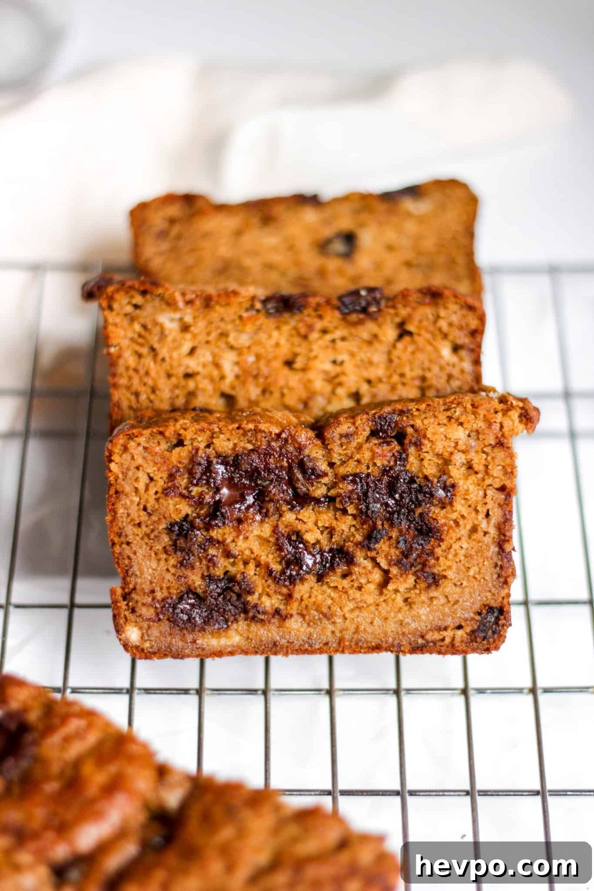 Three slices of pumpkin bread on a metal cooling rack