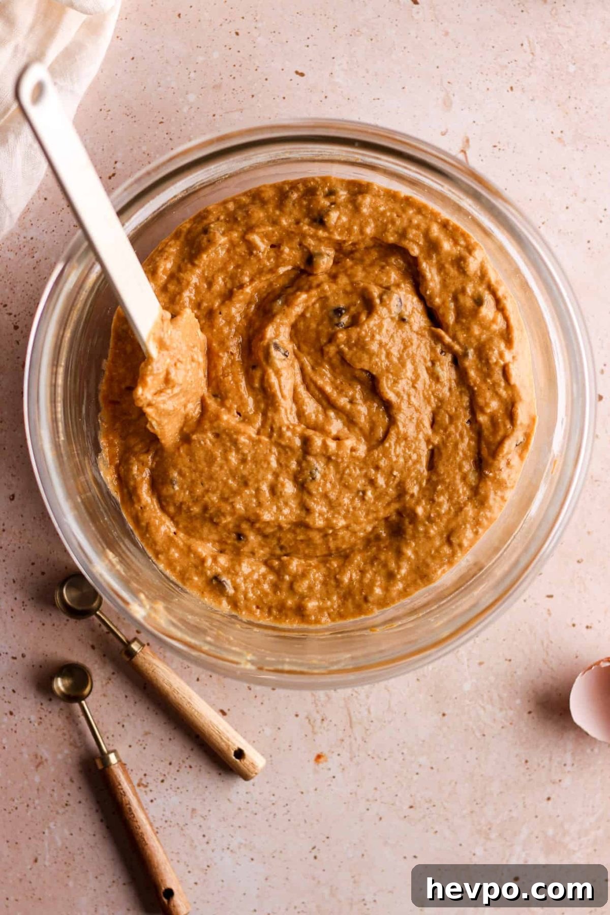 birds eye view of glass mixing bowl with pumpkin banana bread batter fully mixed