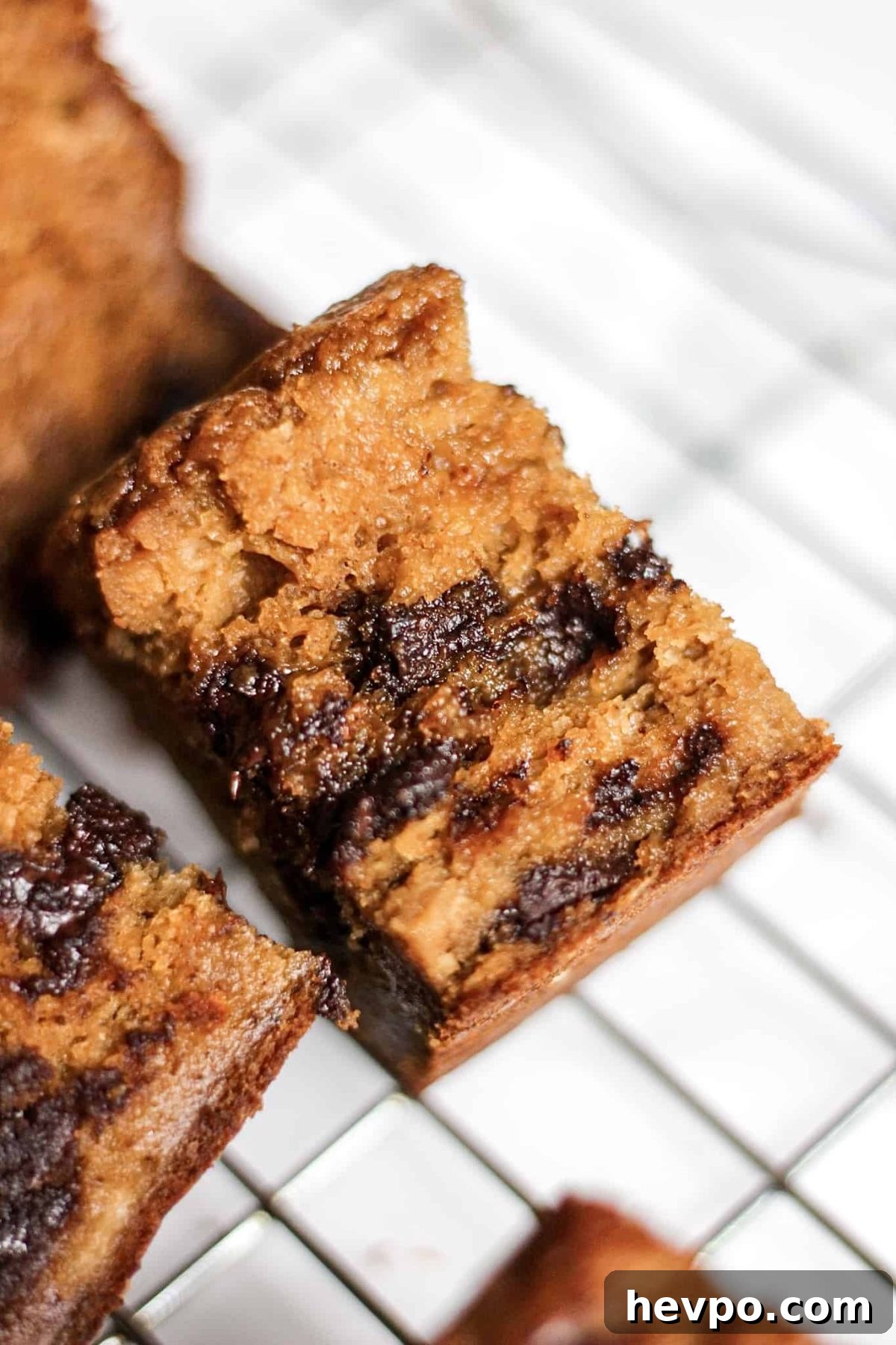 close up shot of pumpkin bread with melted chocolate chunks with blurred cooling rack background