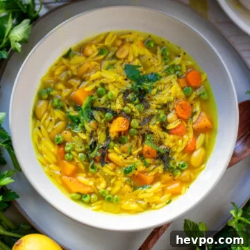Zesty Lemon Orzo Soup Recipe for Comforting Weeknight Meals 4 white bowl with Lemon Orzo Soup with fresh herbs and lemons.
