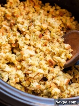 Close up of stove top stuffing in slow cooker with wooden spoon in it.