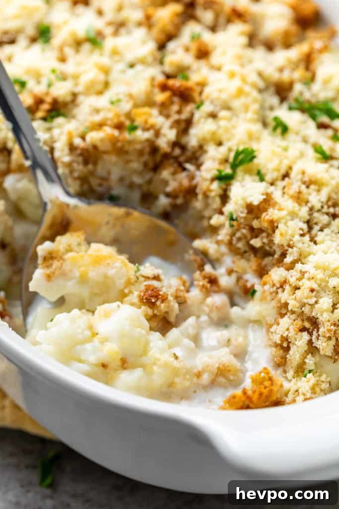 Cheesy Cauliflower Casserole with Crispy Panko Topping 3 Close up view of casserole in a white baking dish.