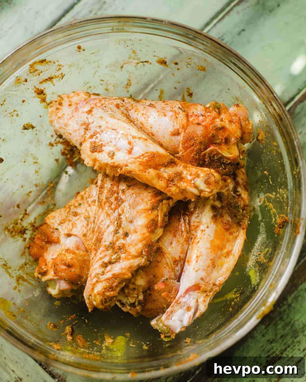 turkey wings covered in seasonings and marinated in a bowl. 