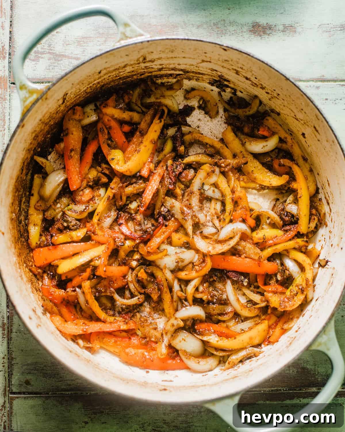 onions, bell peppers, and garlic sauteed in a pot.