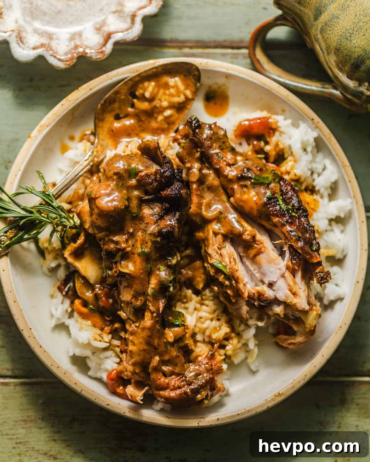 smothered turkey wings on a plate with rice.