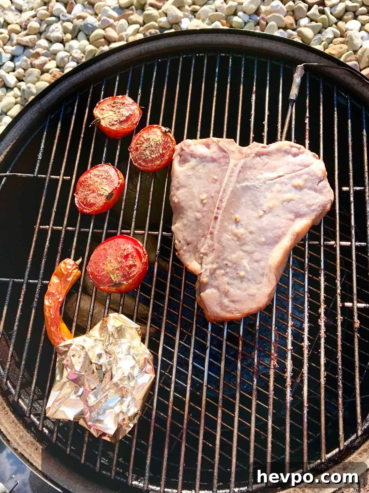 Steak with vegetables on weber grill overhead shot