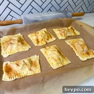 Classic Apple Hand Pies Made with Flaky Puff Pastry 11 Apple hand pies on baking sheet before baking.