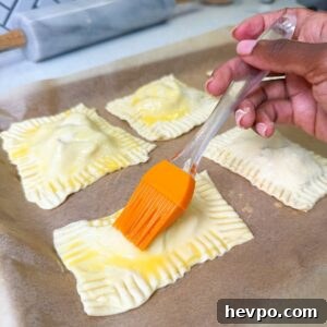 Classic Apple Hand Pies Made with Flaky Puff Pastry 10 Egg wash being brushed on apple hand pies.