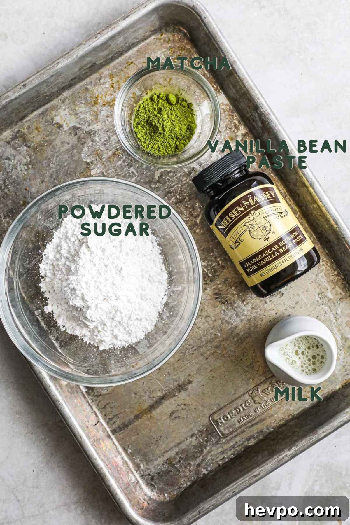 Ingredients to make matcha vanilla bean glaze, including powdered sugar, matcha, vanilla bean paste, and milk.