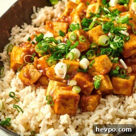 How to Press Tofu for Firmer, Crispier Results 16 Orange Tofu on a bed of rice in serving dish.