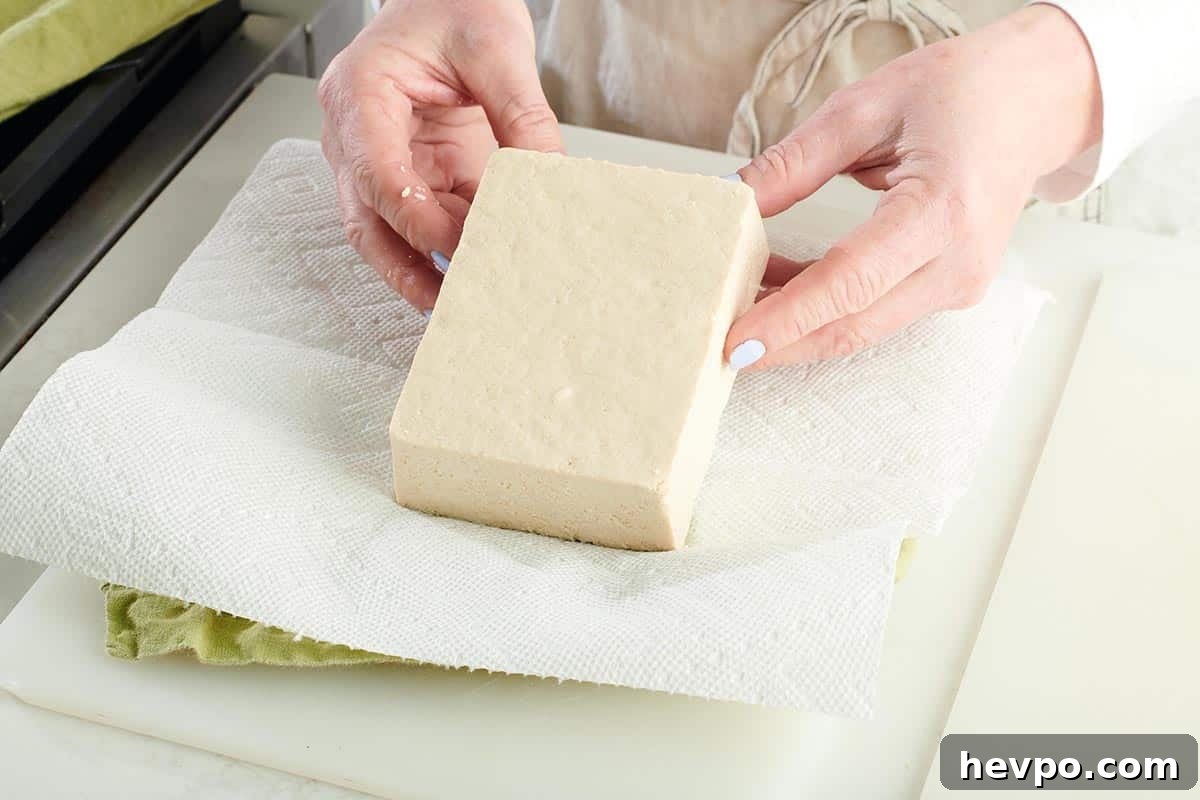 How to Press Tofu for Firmer, Crispier Results 3 Woman placing tofu on paper towels.