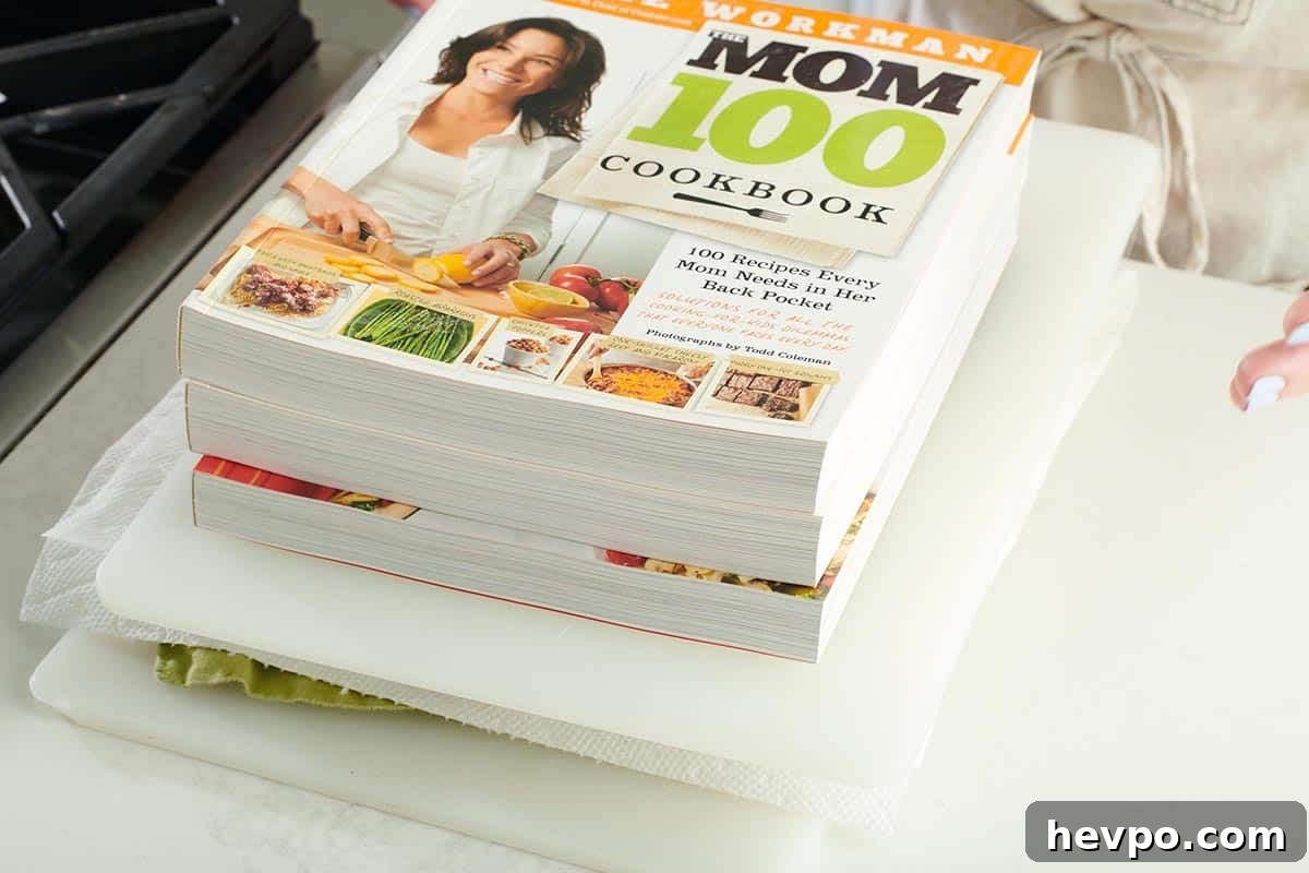 How to Press Tofu for Firmer, Crispier Results 5 The Mom 100 Cookbook pressing tofu on counter.
