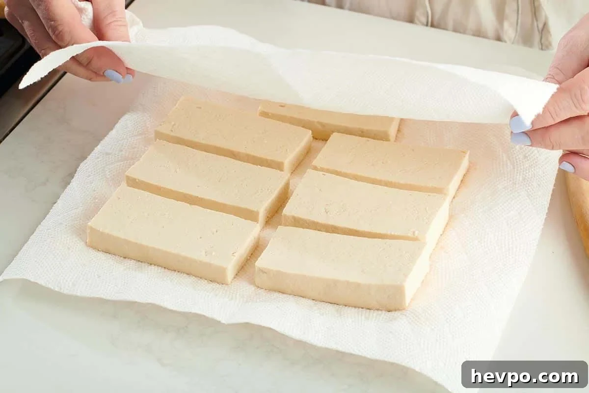 How to Press Tofu for Firmer, Crispier Results 7 Covering sliced tofu with paper towels to press out moisture.
