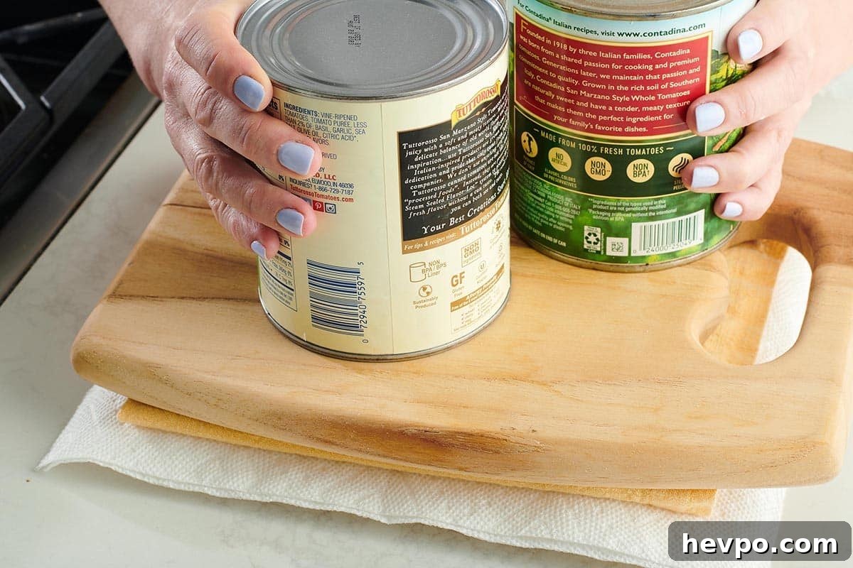 How to Press Tofu for Firmer, Crispier Results 8 Woman placing large cans onto a cutting board pressing tofu.
