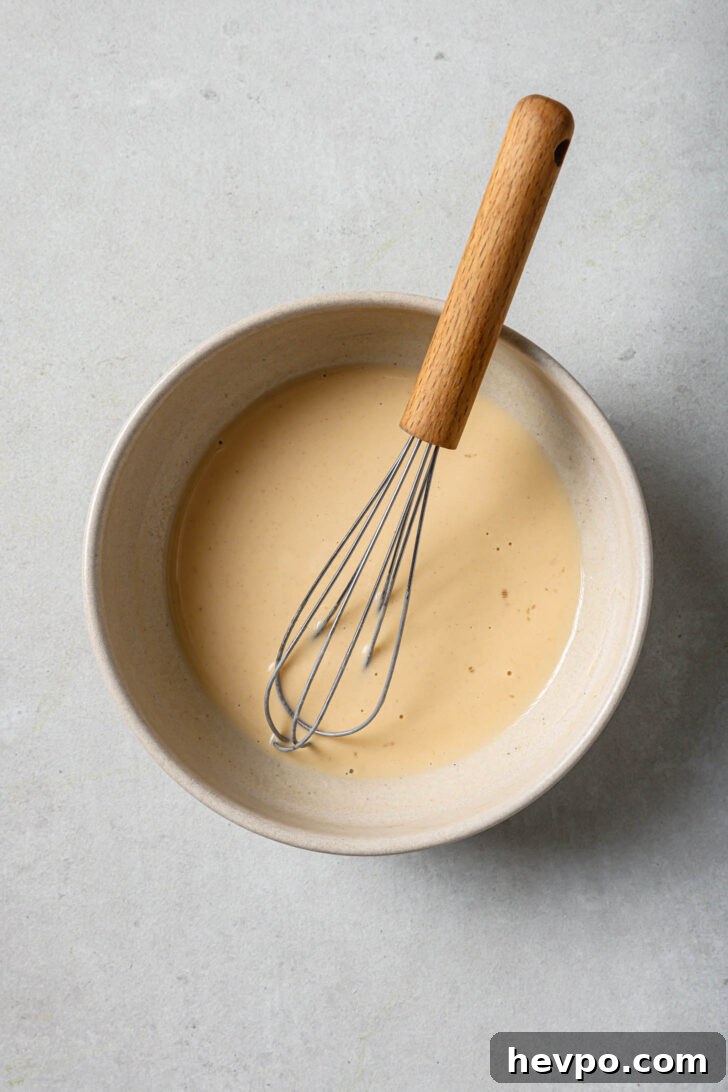Water, flour and egg whisked in a bowl to make the binder for Chicken Spring Rolls.