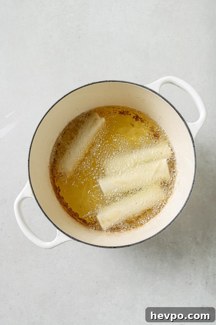 Frying Chicken Spring Rolls in a dutch oven.