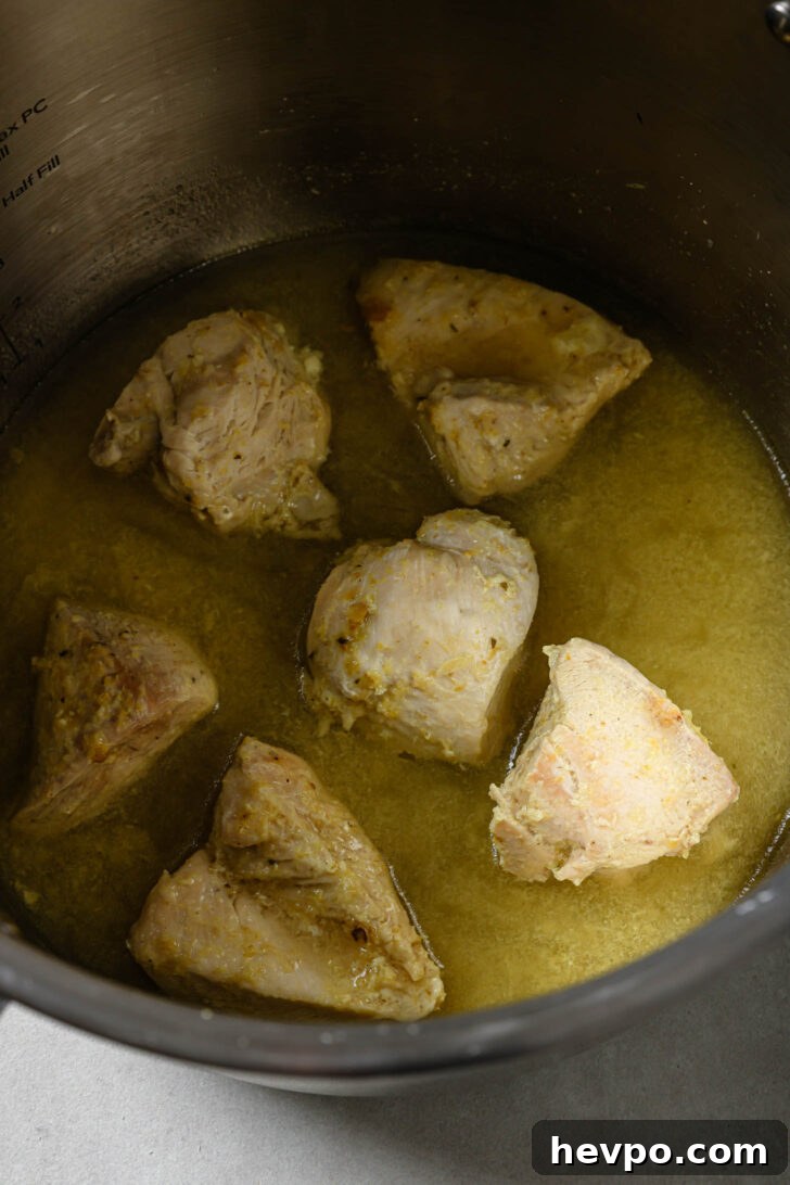 Boiling chicken with salt, ginger, garlic and bouillon powder to make Chicken Spring Rolls.