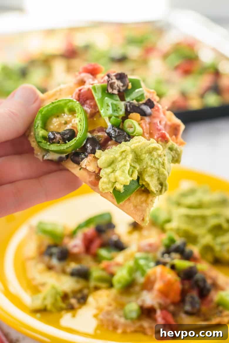 Vegetarian nachos with beans, peppers, cheese, and guacamole