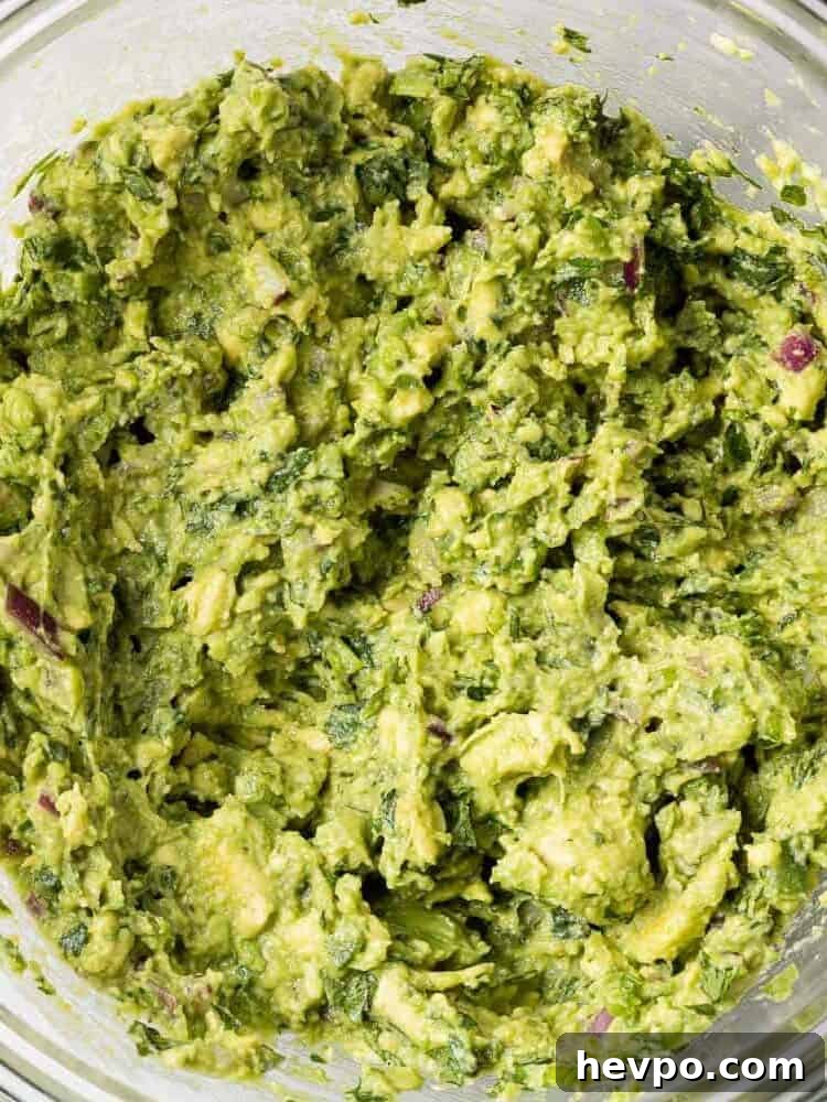 Guacamole in a clear glass mixing bowl.