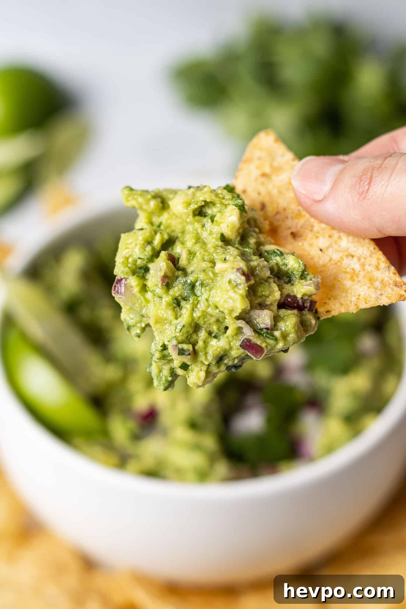 Guacamole on a chip held in a hand.