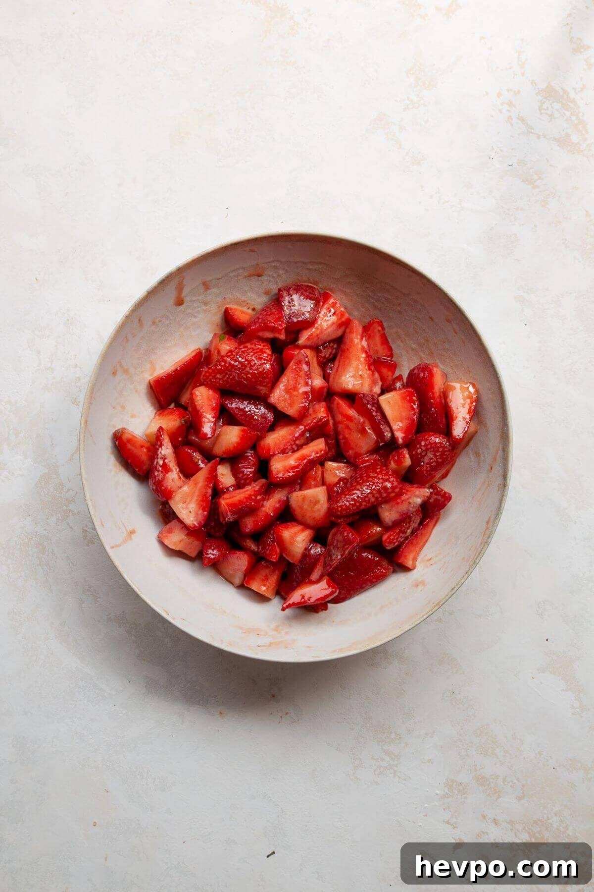 Strawberry Crumble with Oat Topping Recipe 4 Fresh or frozen strawberries tossed with lemon juice, cornstarch, and coconut sugar in a white mixing bowl.