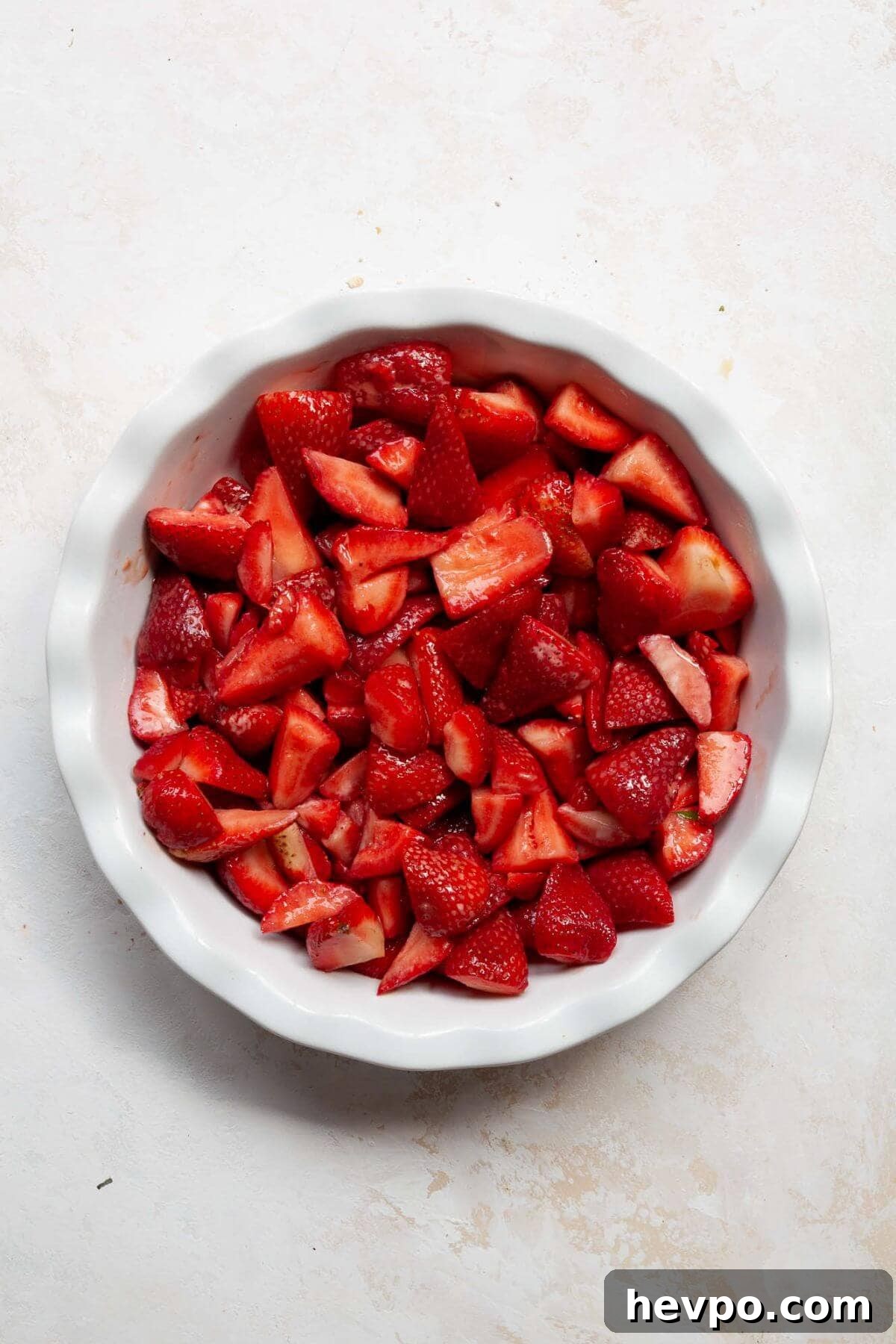 Strawberry Crumble with Oat Topping Recipe 5 Sliced strawberries spread in a greased pie dish before being topped with oat crumble.