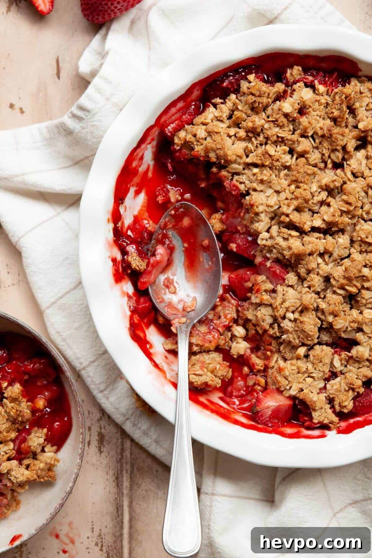 Strawberry Crumble with Oat Topping Recipe 9 Spoon scooping into a warm strawberry crumble showing the jammy filling and crisp oat topping.