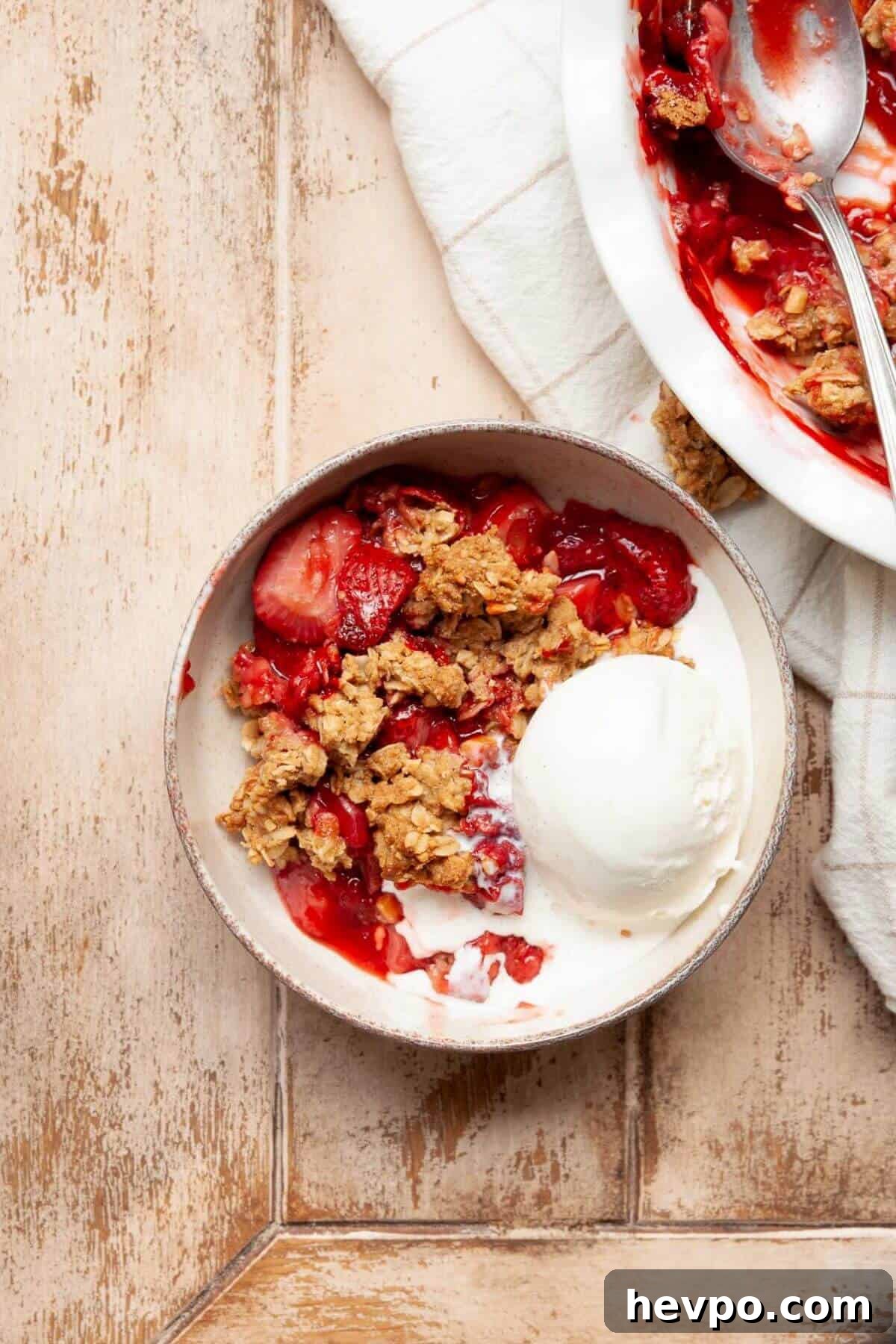 Strawberry Crumble with Oat Topping Recipe 10 Gluten-free strawberry crumble in a bowl with vanilla ice cream.