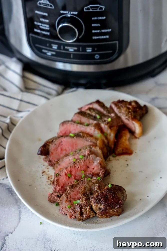 picture of medium rare sliced new york strip steak on a plate in front of an instant pot