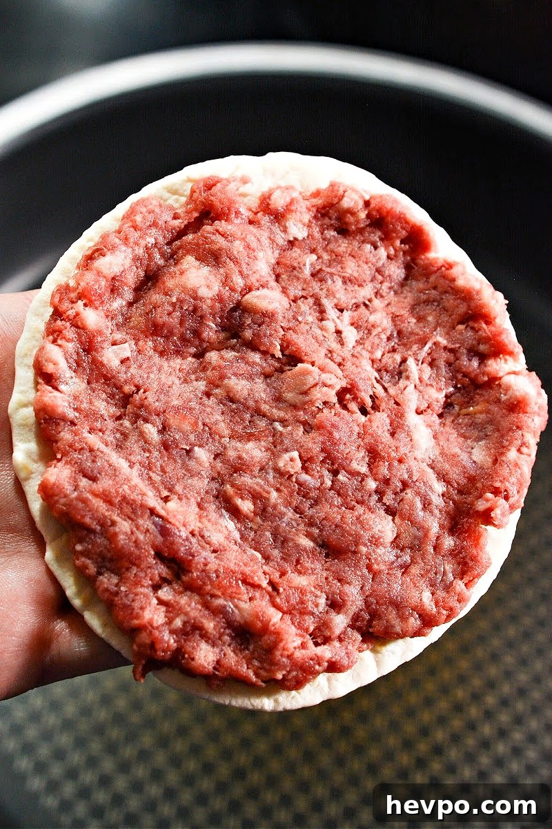 Raw hamburger meat on a keto tortilla