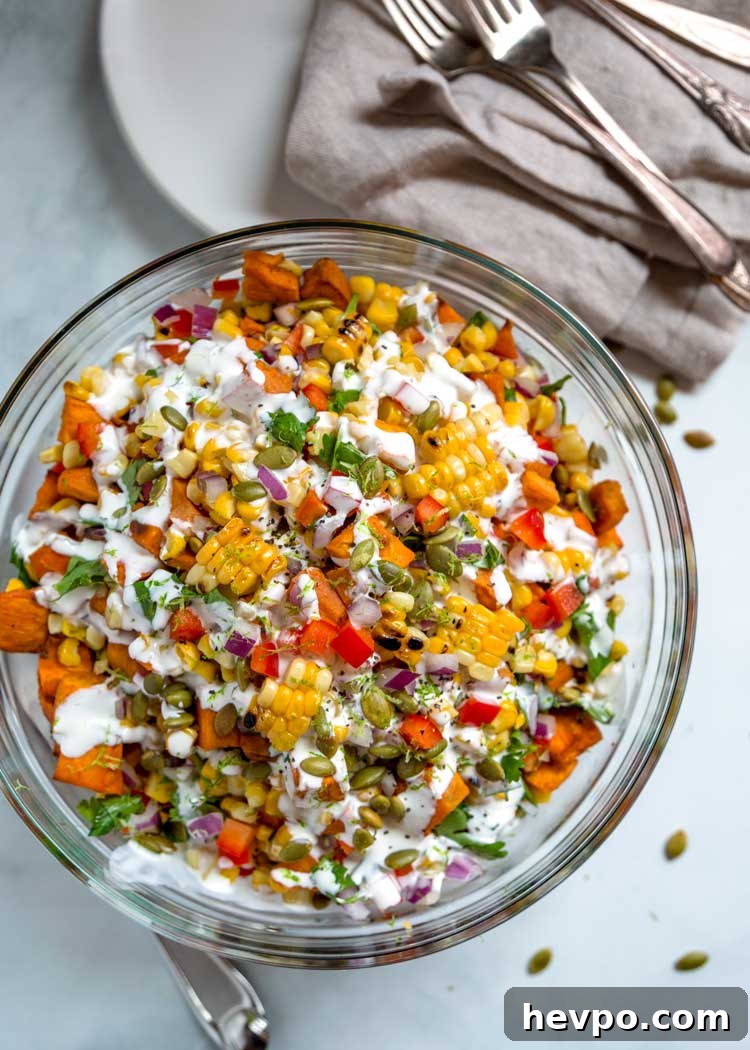 This healthy Sweet Potato and Corn Salad has roasted sweet potatoes and corn, bell peppers and pumpkins seeds tossed in a Mexican crema sauce with lime. overhead photo of Sweet Potato and Corn Salad