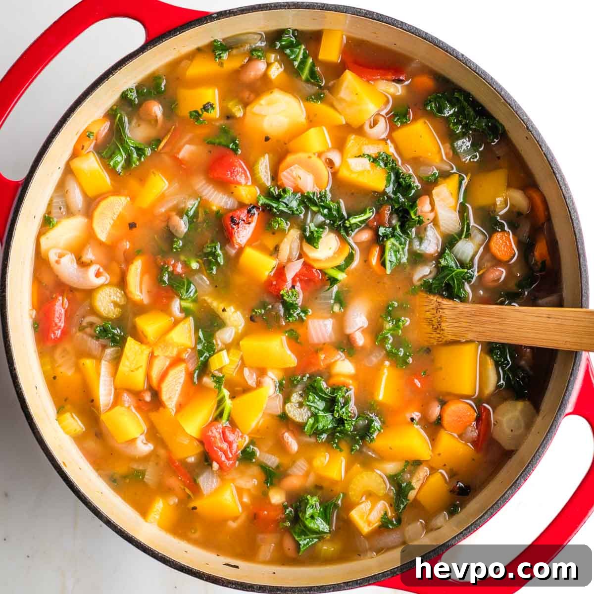 Autumn Vegan Minestrone: Hearty Fall Vegetable Soup 11 Minestrone with chunks of root veggies and butternut squash in broth in a dutch oven.