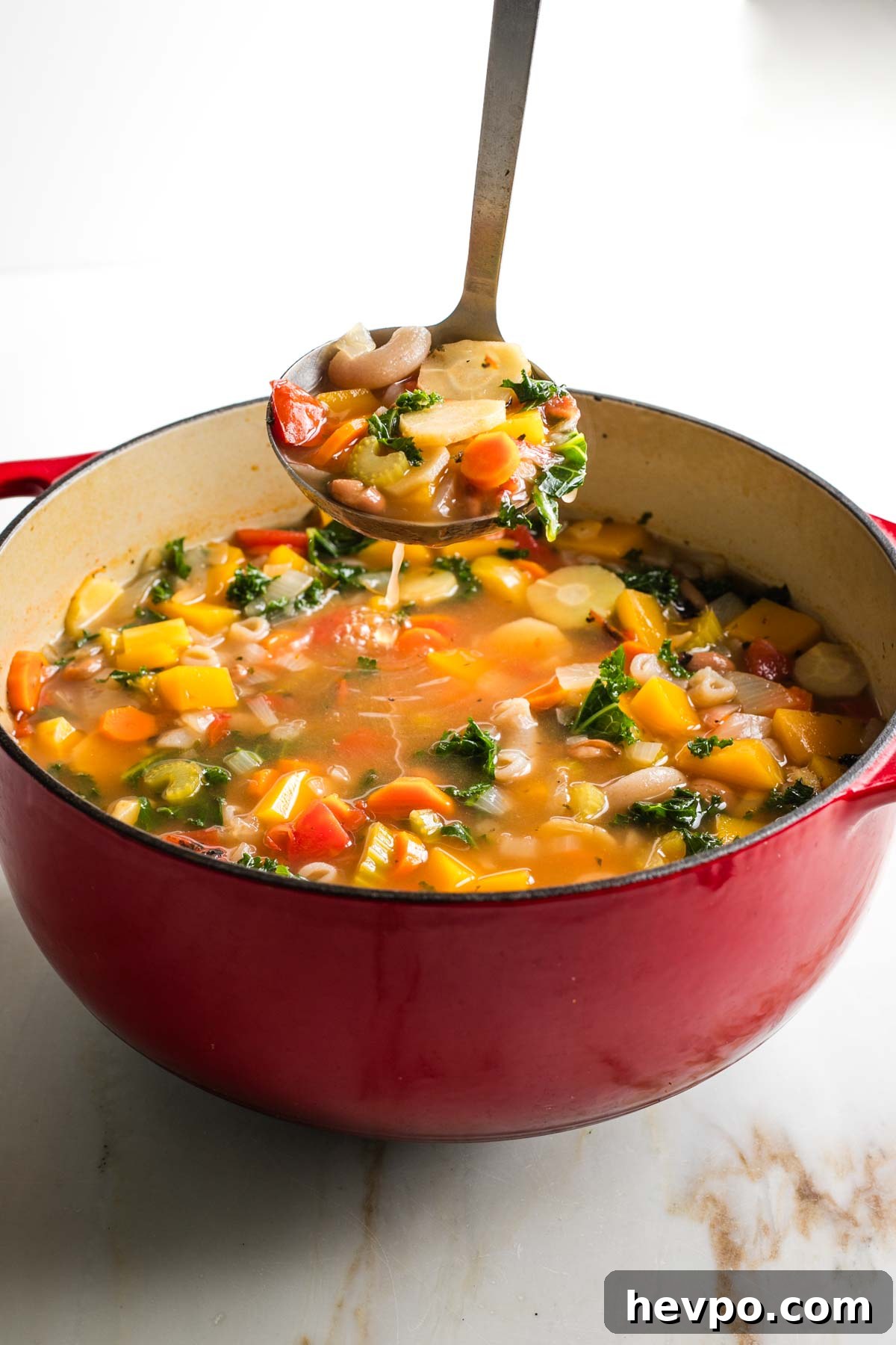 Autumn Vegan Minestrone: Hearty Fall Vegetable Soup 12 Ladling chunky minestrone soup from a dutch oven.