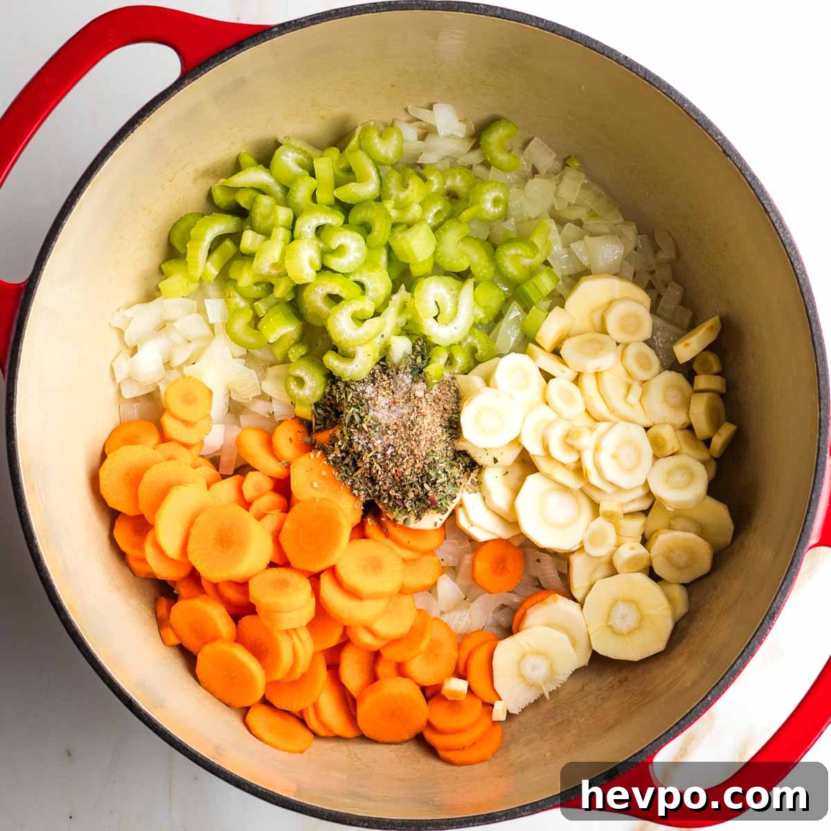Autumn Vegan Minestrone: Hearty Fall Vegetable Soup 6 Dutch oven with carrots, parsnips, spices and celery on top of sauteed onions.