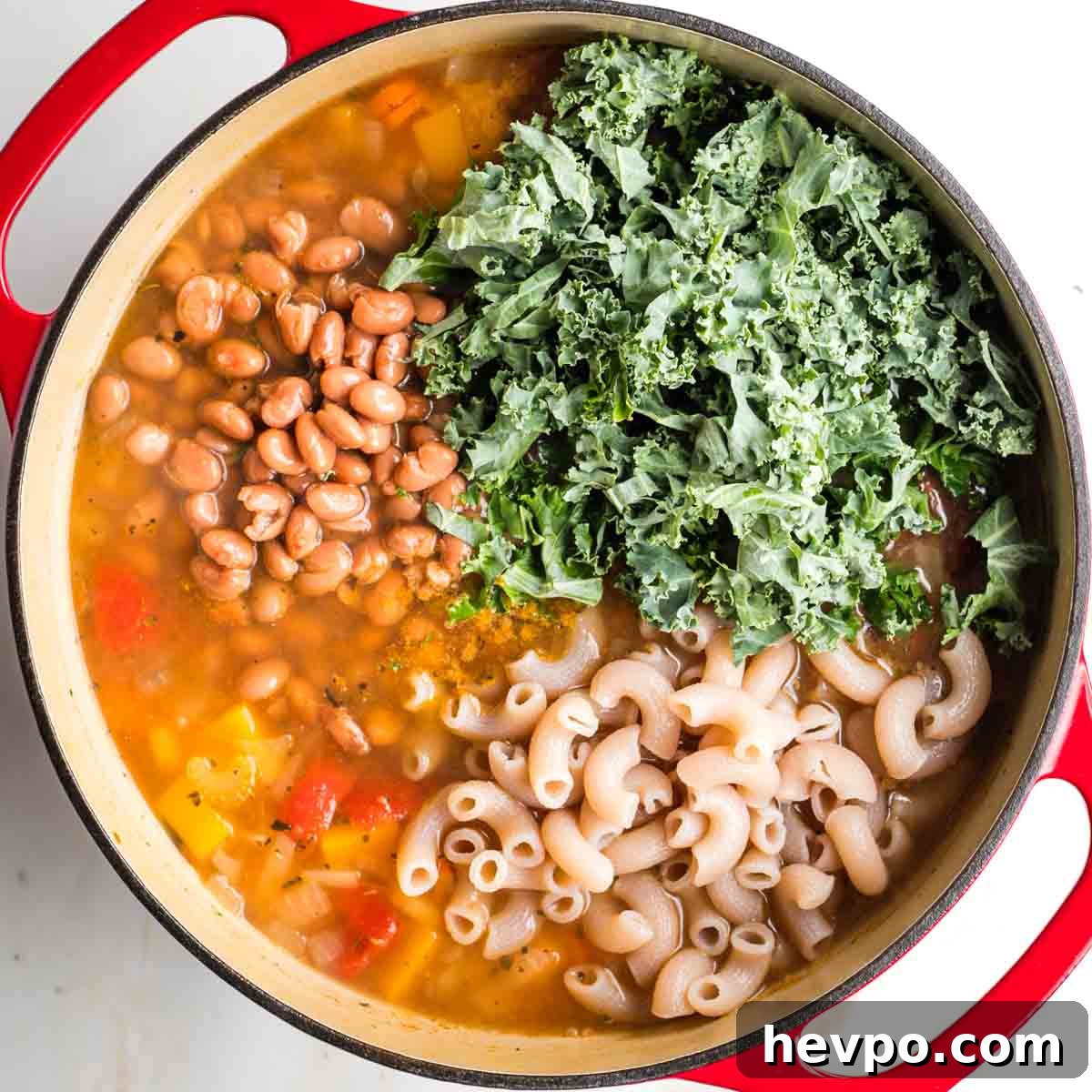 Autumn Vegan Minestrone: Hearty Fall Vegetable Soup 10 Chopped kale, pinto beans and cooked pasta in a pot of veggie soup.