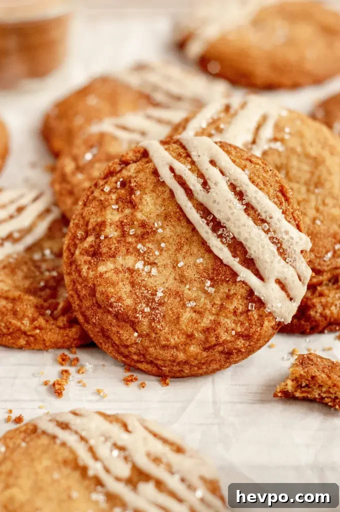 Golden brown maple brown sugar cookies with a light tan salted maple icing drizzled on top of each cookie.