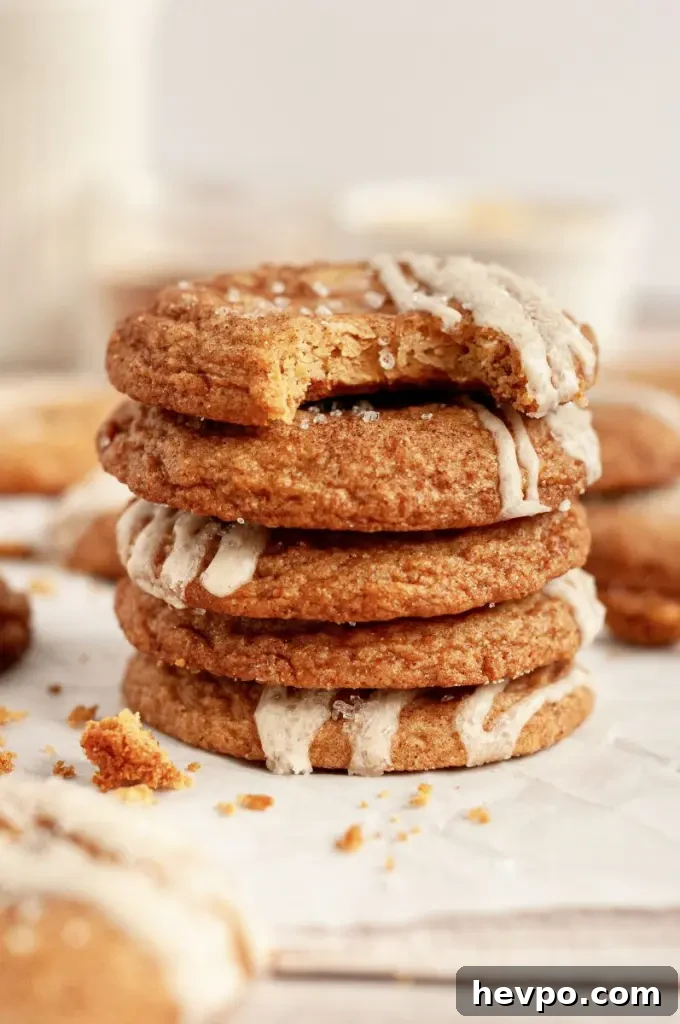 Golden brown maple brown sugar cookies with a light tan salted maple icing drizzled on top of each cookie.