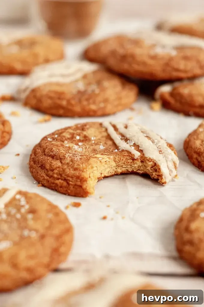Golden brown maple brown sugar cookies with a light tan salted maple icing drizzled on top of each cookie.