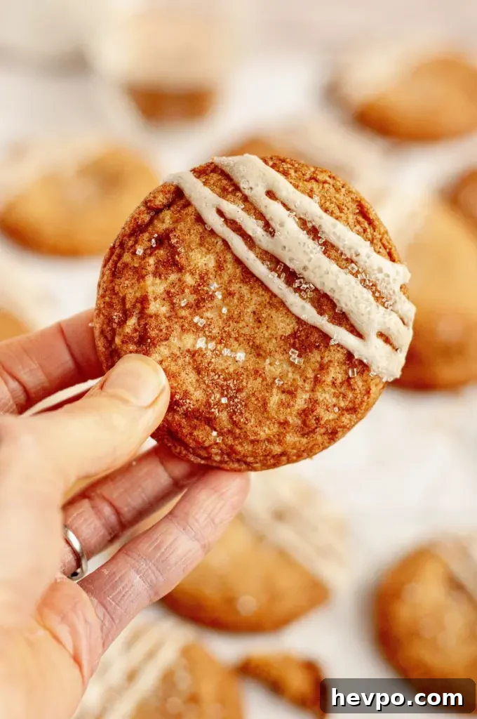 Golden brown maple brown sugar cookies with a light tan salted maple icing drizzled on top of each cookie.