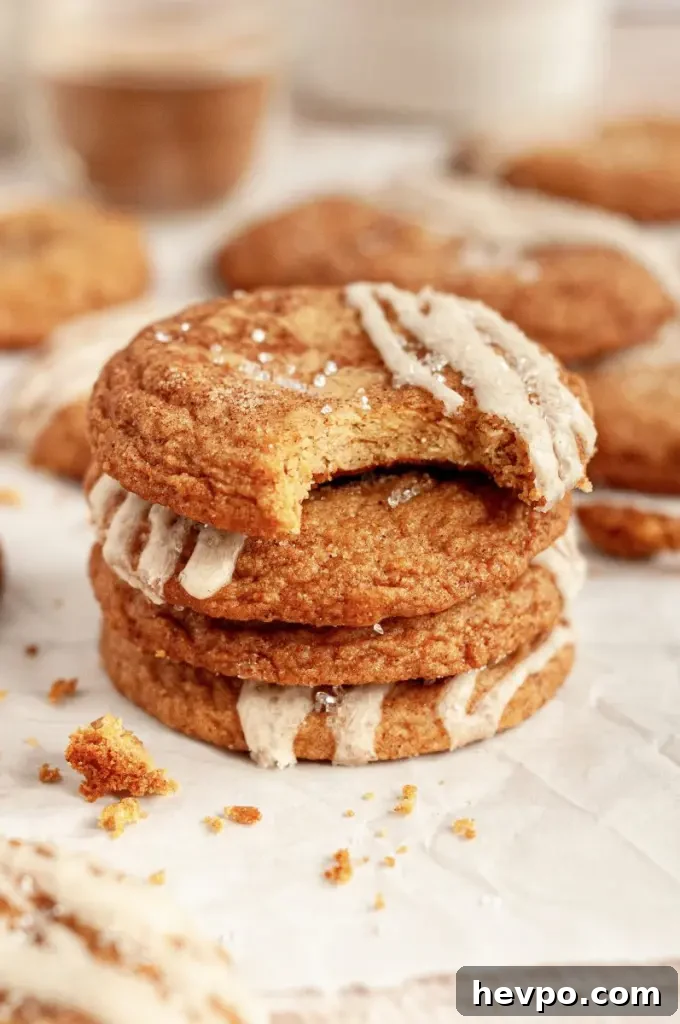 Golden brown maple brown sugar cookies with a light tan salted maple icing drizzled on top of each cookie.