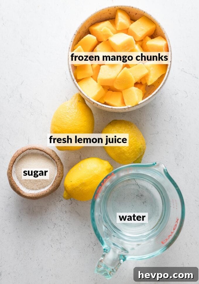 Labeled overhead photo of fresh lemons, cubed frozen mango chunks, two tablespoons of granulated sugar, and water in a liquid measuring cup.