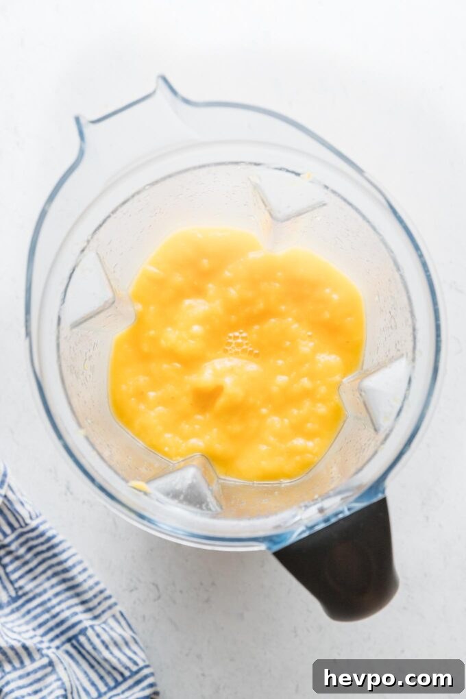 Large blender full of a frozen mango lemonade.
