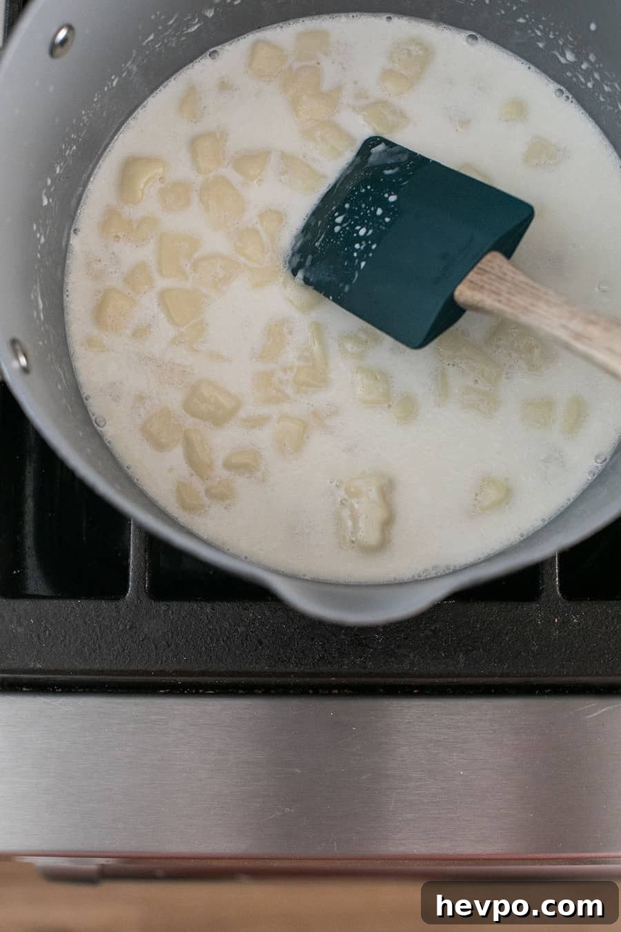 Melting American white cheese and milk together in a nonstick pan