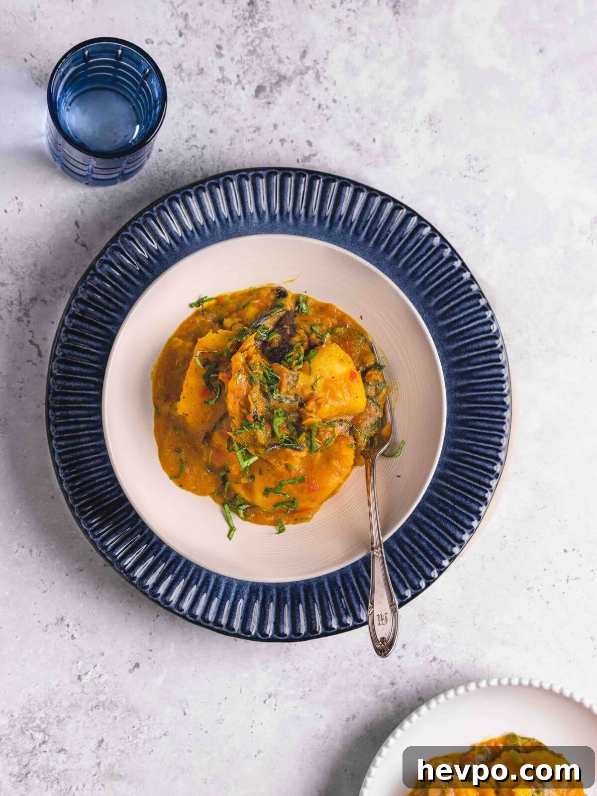 Asaro: Authentic Nigerian Yam Porridge Recipe for Flavorful Comfort 8 A serving of porridge yam in a white bowl with a glass of water.